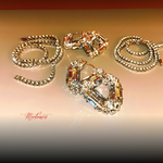 Gold jewelry set with necklace and earrings on a beige background