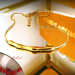 Gold necklace on a white surface with a blurred background
