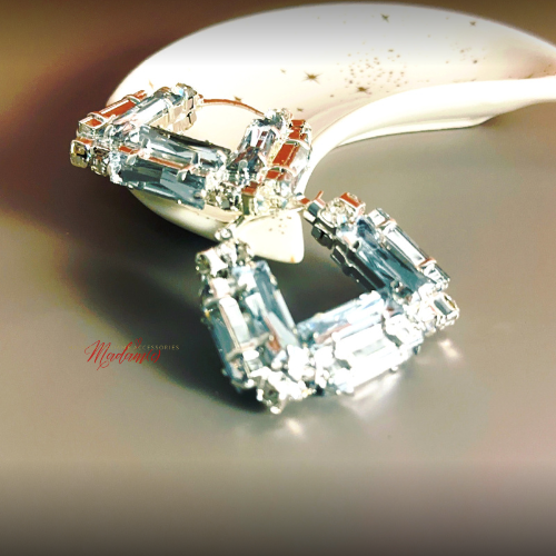 Close-up of a diamond earring on a reflective surface with &