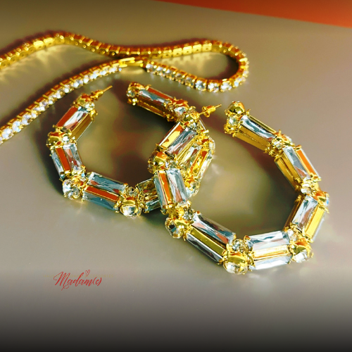 Gold necklace with gemstones on a reflective surface