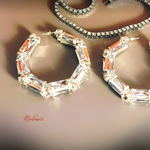 Elegant hoop earrings with clear gemstones on a neutral background