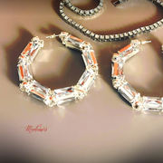 Elegant hoop earrings with clear gemstones on a neutral background