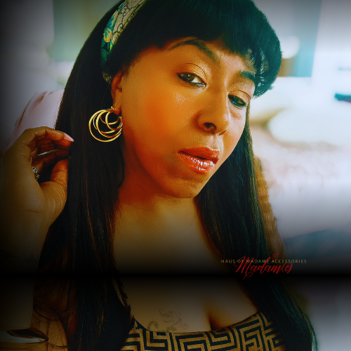 Woman wearing gold earrings with a blurred background