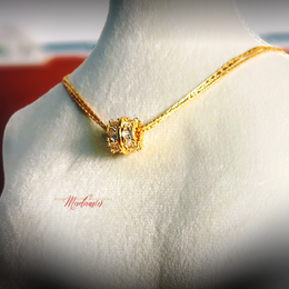 Gold necklace with a diamond pendant on a mannequin bust, branded 'Madamis'.