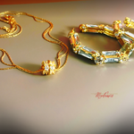 Gold necklace and bracelet with gemstones on a gradient background