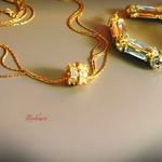 Gold necklace with diamond pendant on a beige background