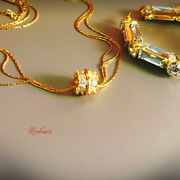 Gold necklace with diamond pendant on a beige background