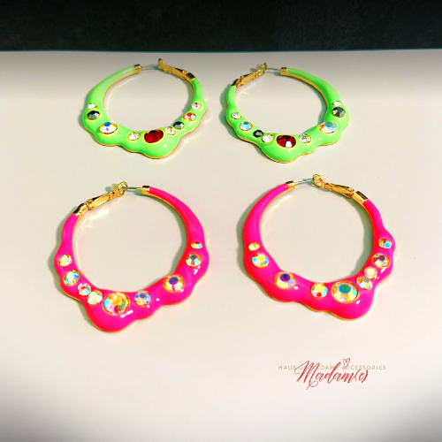 Four colorful hoop earrings with gemstone-like embellishments on a light background.