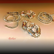 Gold jewelry set with necklace and earrings on a beige background