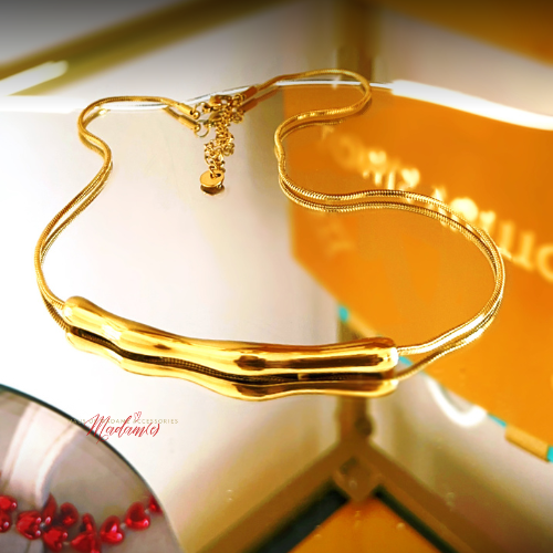 Gold necklace on a white surface with a blurred background